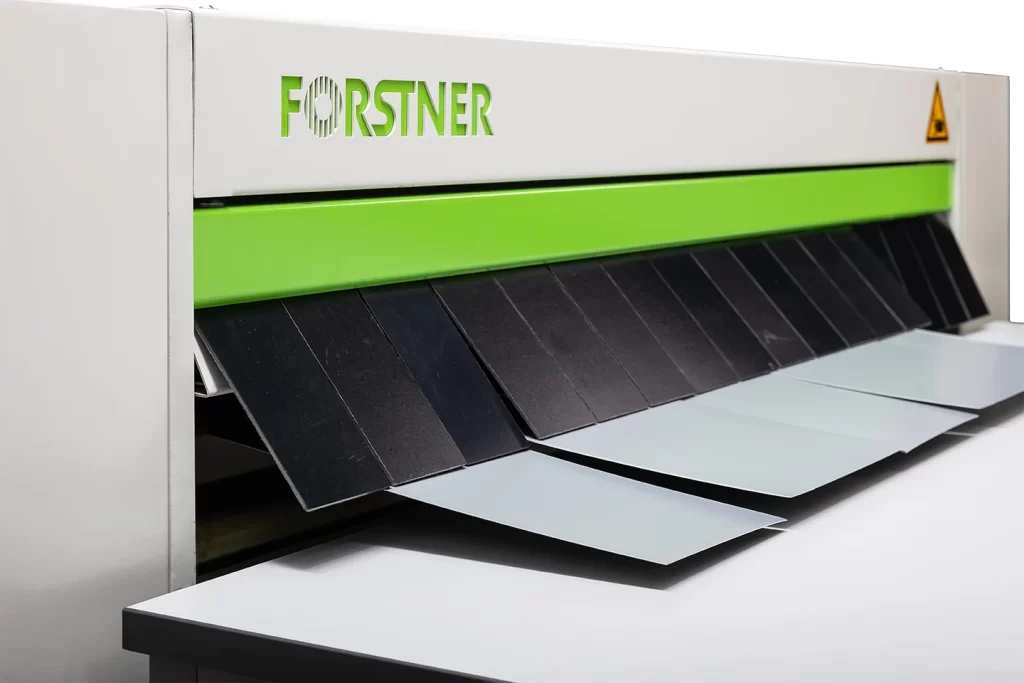 slitted material outfeeds on table fron cut to length machine nuslit on white background