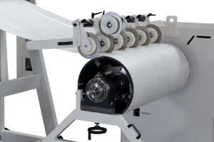 close up of recoiler winding sheet metal on white background